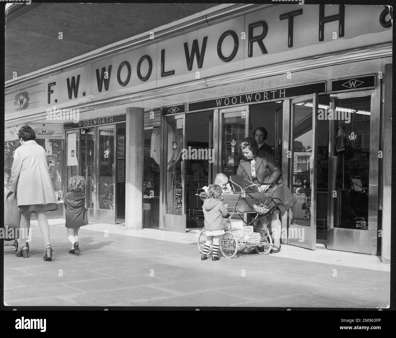 Frauen und Kinder vor Woolworth's in Crawley, Sussex, England. Stockfoto