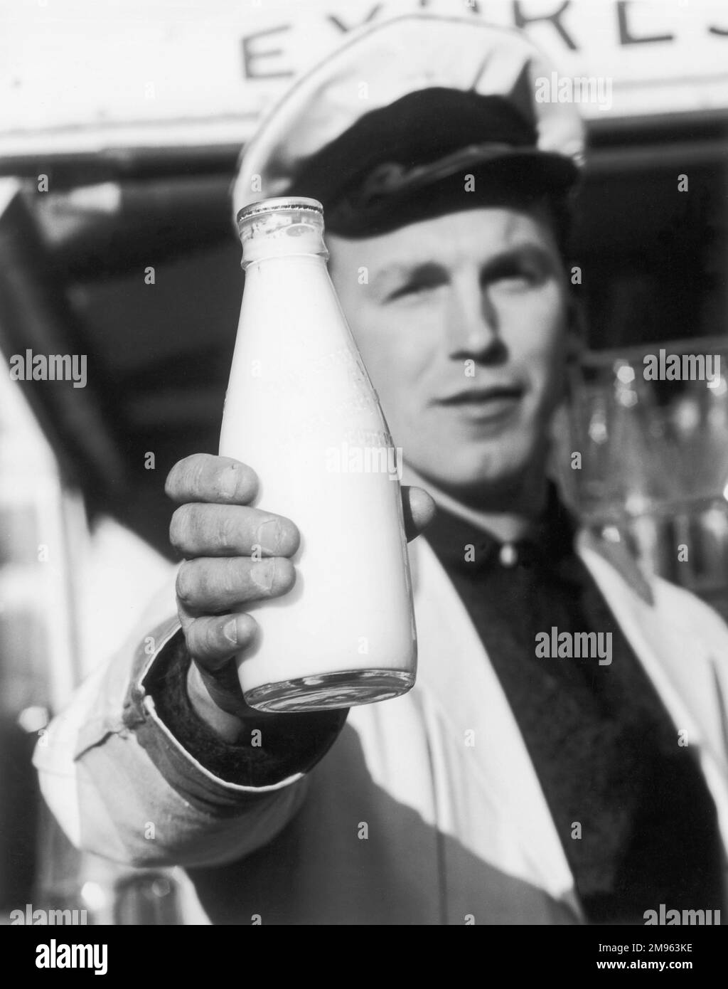 Ein Milchmann hält eine Flasche Milch. Stockfoto