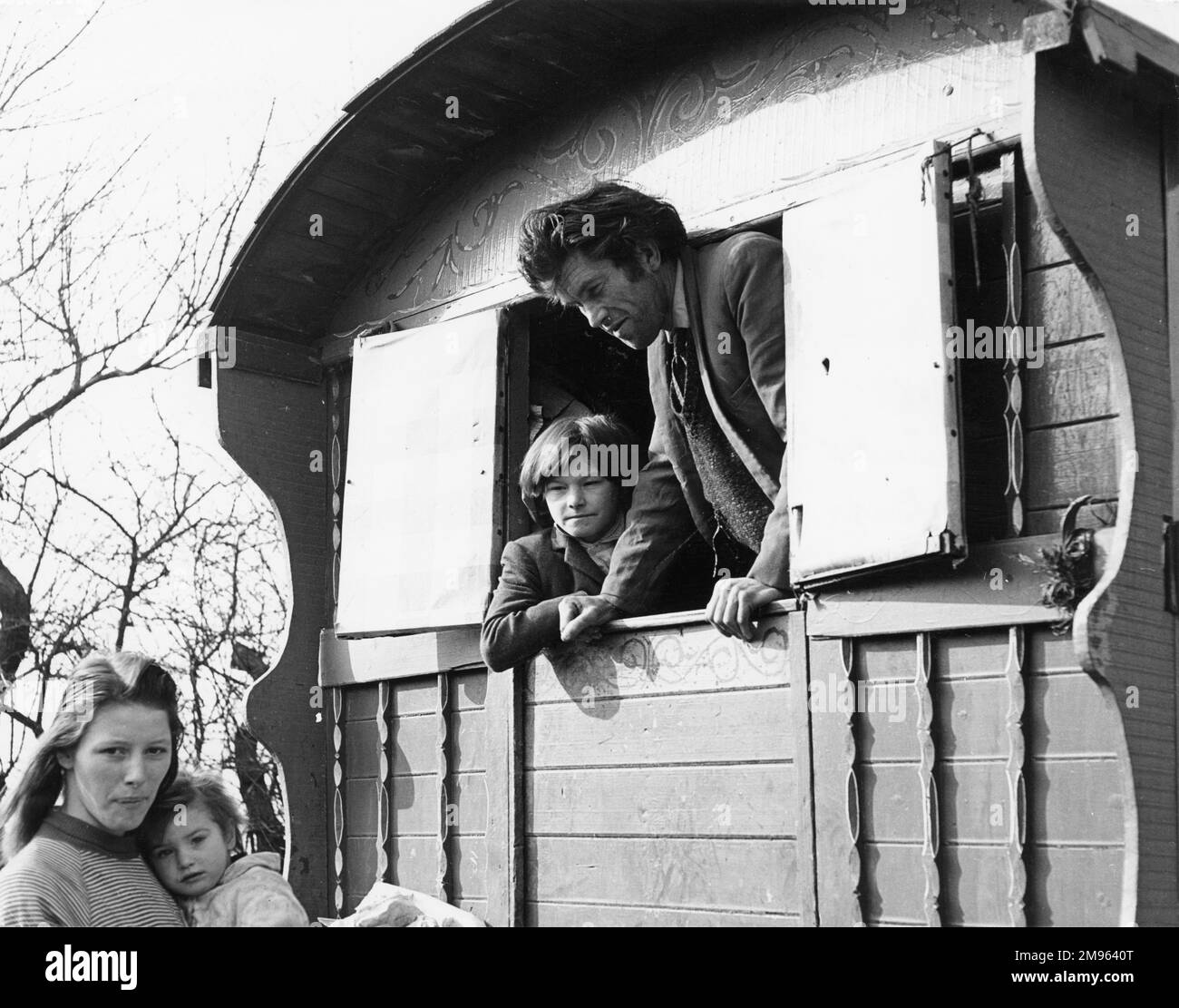 Eine Zigeunerfamilie, Ehemann und Sohn beobachten Frau und jüngeres Kind von der Hintertür ihres Wohnwagens aus in einem Zigeunerlager in Penshurst, Kent, England. Stockfoto