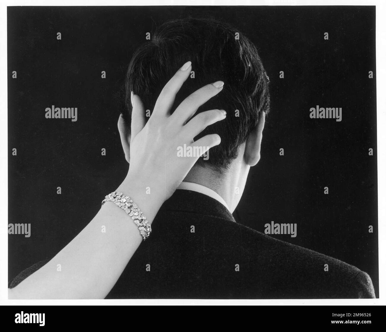 Eine Frau legt ihre Hand auf den Hinterkopf eines Mannes. Stockfoto