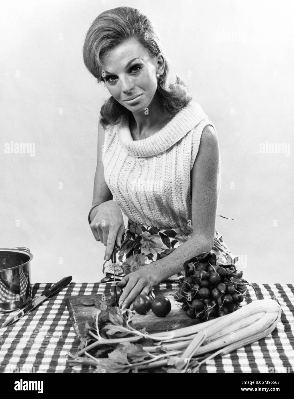 Eine Frau schneidet ein paar Tomaten. Stockfoto