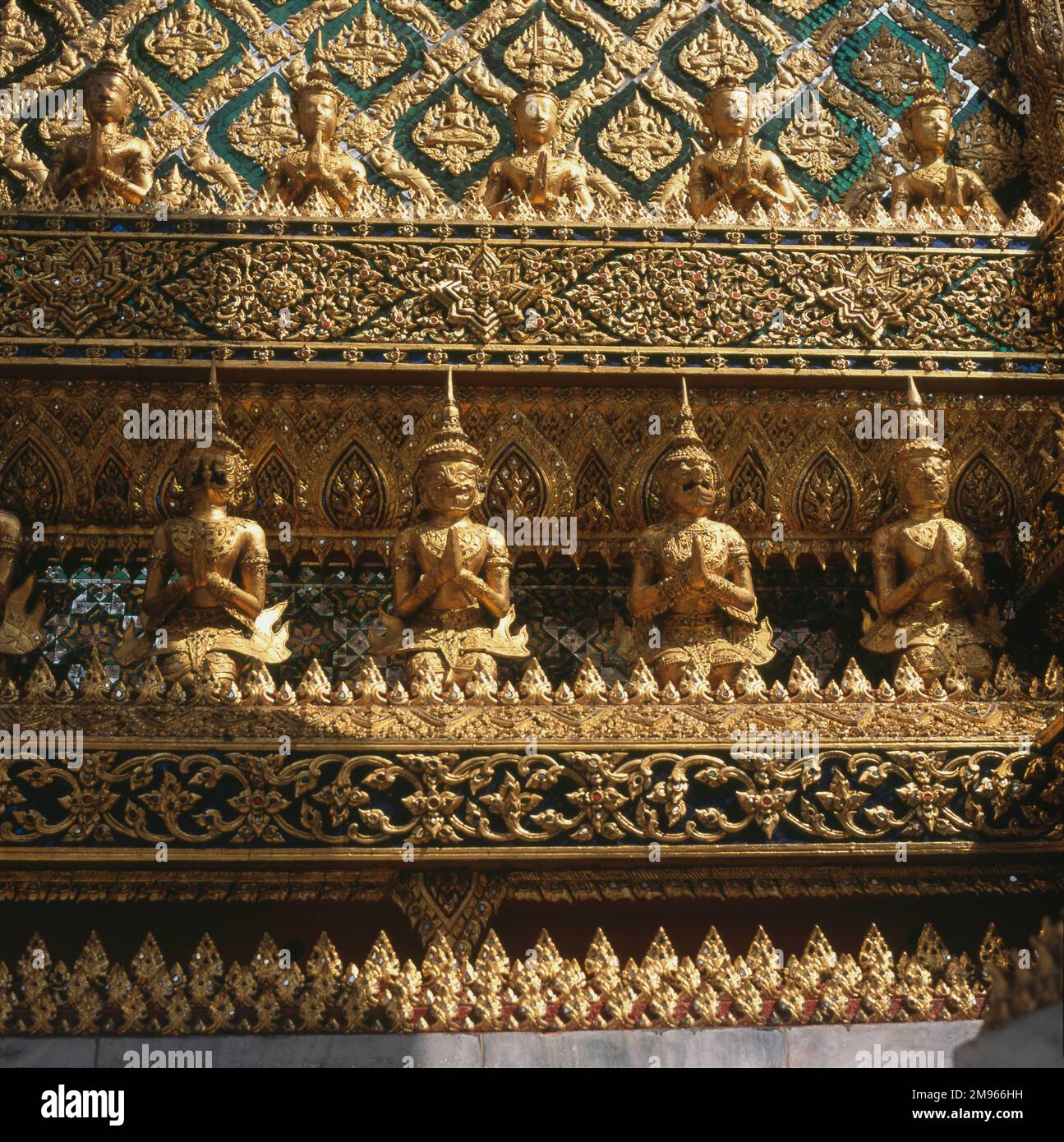 Eine Reihe von Hüterstatuen entlang der aufwendigen Phra Mondop (Bibliothek) des Wat Phra Keo (Tempel des Smaragd-Buddha), Bangkok, Thailand. Der Bau begann 1785 -- der Tempel besteht aus hoch dekorierten heiligen Gebäuden, Statuen und Pagoden. Stockfoto