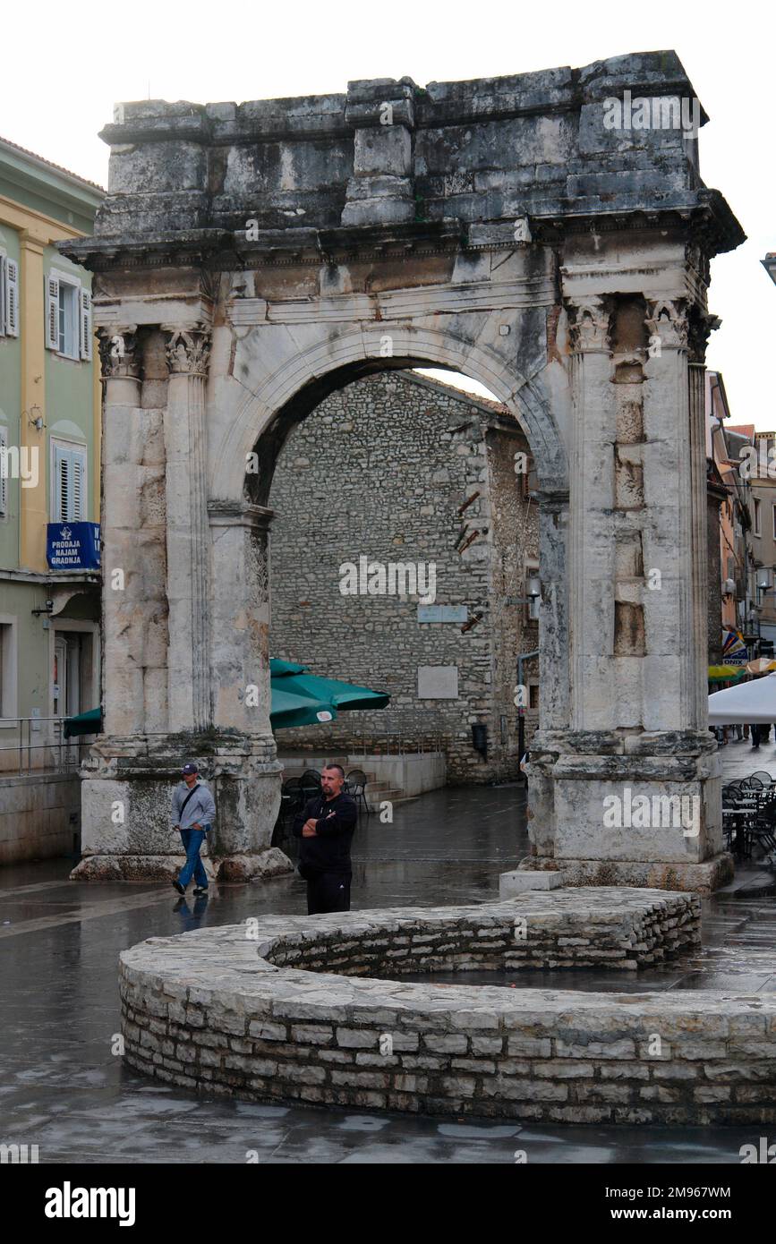 Der Triumphbogen der Sergii in Pula an der Westküste Istriens, Kroatien. Dieser antike römische Bogen erinnert an drei Brüder der Familie Sergii, insbesondere Lucius Sergius Lepidus, ein Tribun, der in der Schlacht von Actium kämpfte. Er wurde von der Frau von Lepidus, Salvia Postuma Sergia, bezahlt und wurde ursprünglich als Stadttor benutzt. Stockfoto