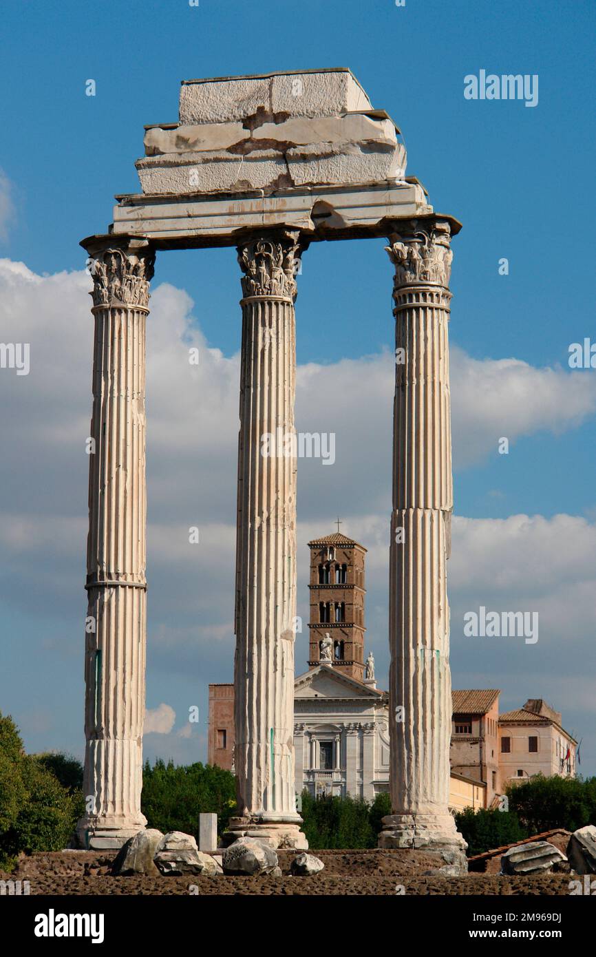 Blick auf drei korinthische Säulen im Forum Romanum, oder Forum Romanum, mit der Basilika di Massenzio (Basilika von Maxentius und Konstantin) im Hintergrund. Stockfoto