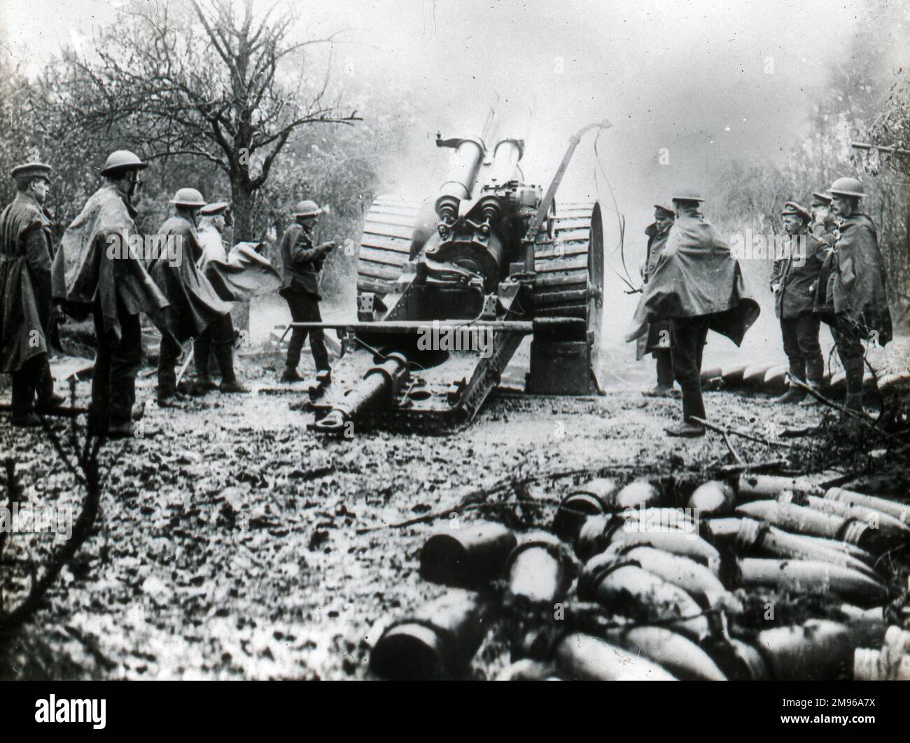 Eine Gruppe von Soldaten feuert mit einer großen Feldpistole. Im rechten Vordergrund warten mehrere Patronen darauf, abgefeuert zu werden. Stockfoto