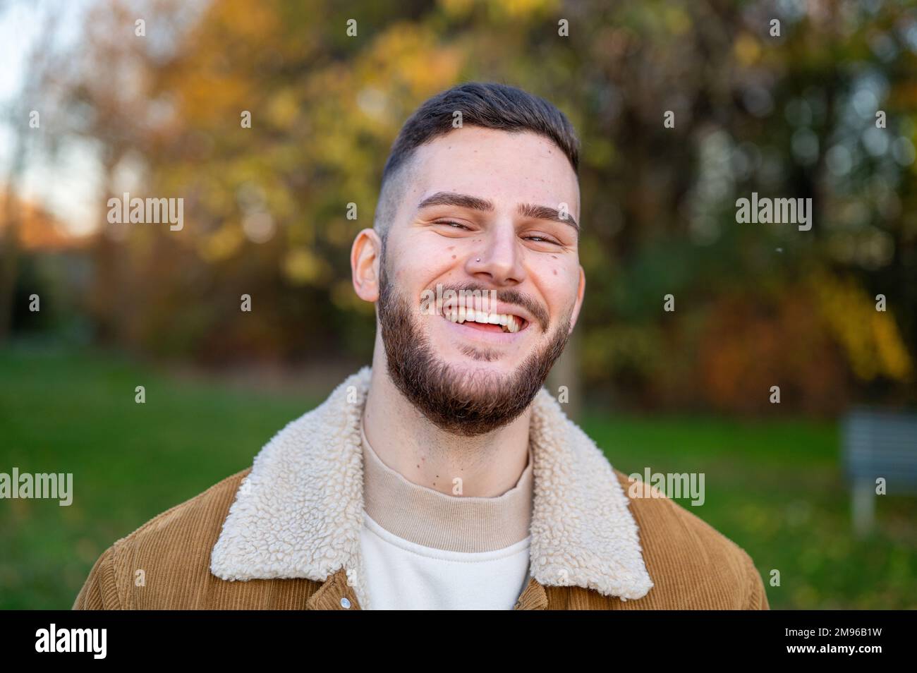 Bärtiger Mann, junger Mann mit Bart draußen in einem öffentlichen Park Stockfoto