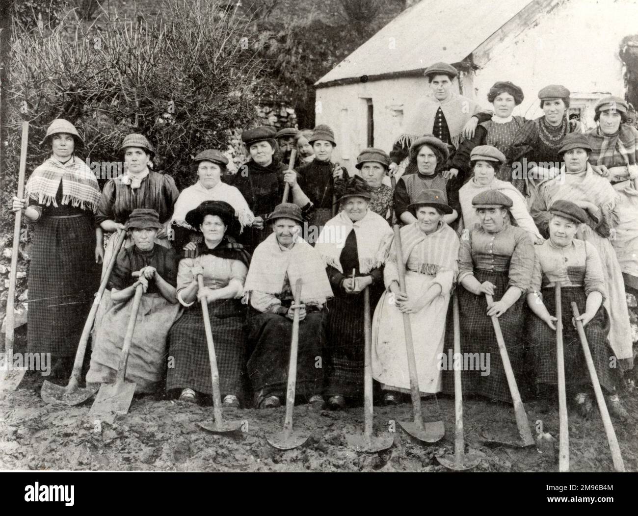 Eine Gruppe von zwanzig walisischen Straßenbauerinnen in Pembrokeshire, Dyfed, Südwales, die ihre Pik in der Hand halten. Sie bauten 1903-4 die Straße nach Hook, um den Transport zur Grube zu erleichtern. Sie arbeiteten auch in der Grube selbst und sammelten „Boughs“, die als Grubenstützen verwendet wurden, für die sie neunzig pro Hundertgewicht erhielten. Stockfoto