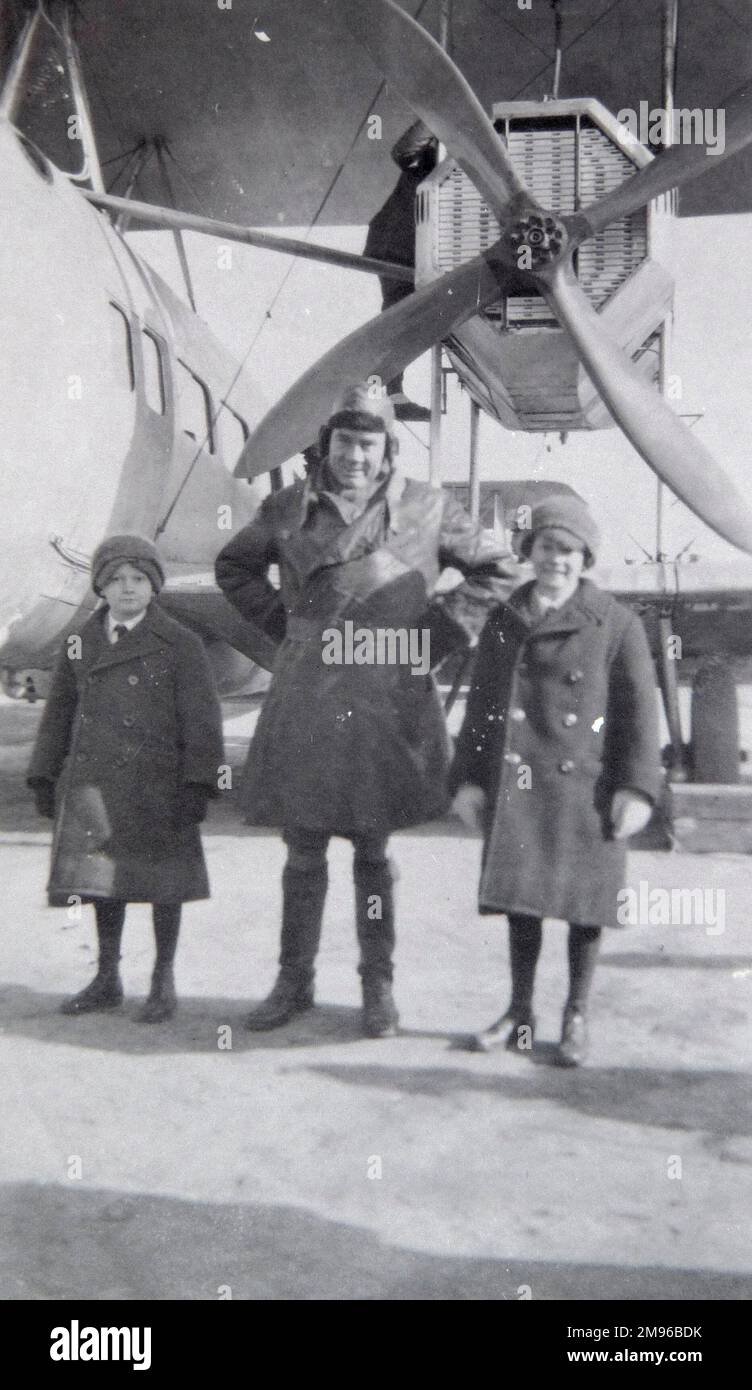 Ein Pilot steht mit zwei Kindern vor einem Flugzeug, das sie auf einem Flug von London nach Paris nimmt, in den frühen Tagen der Luftfahrt. Stockfoto