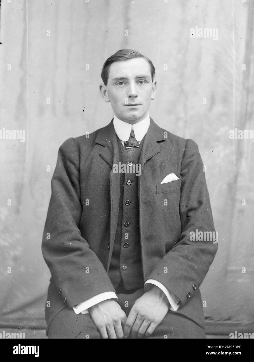 Ein blasser junger Mann in einem Anzug, der zu groß für ihn aussieht, im Studio des Fotografen, Mid Wales. Stockfoto