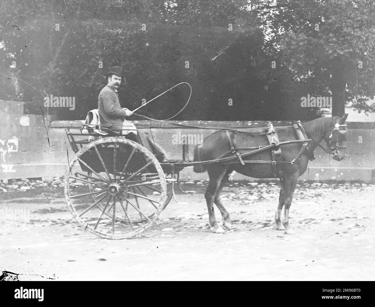 Ein Gentleman, der ein Pferd und eine Falle in einer Straße in Mid Wales fährt. Stockfoto