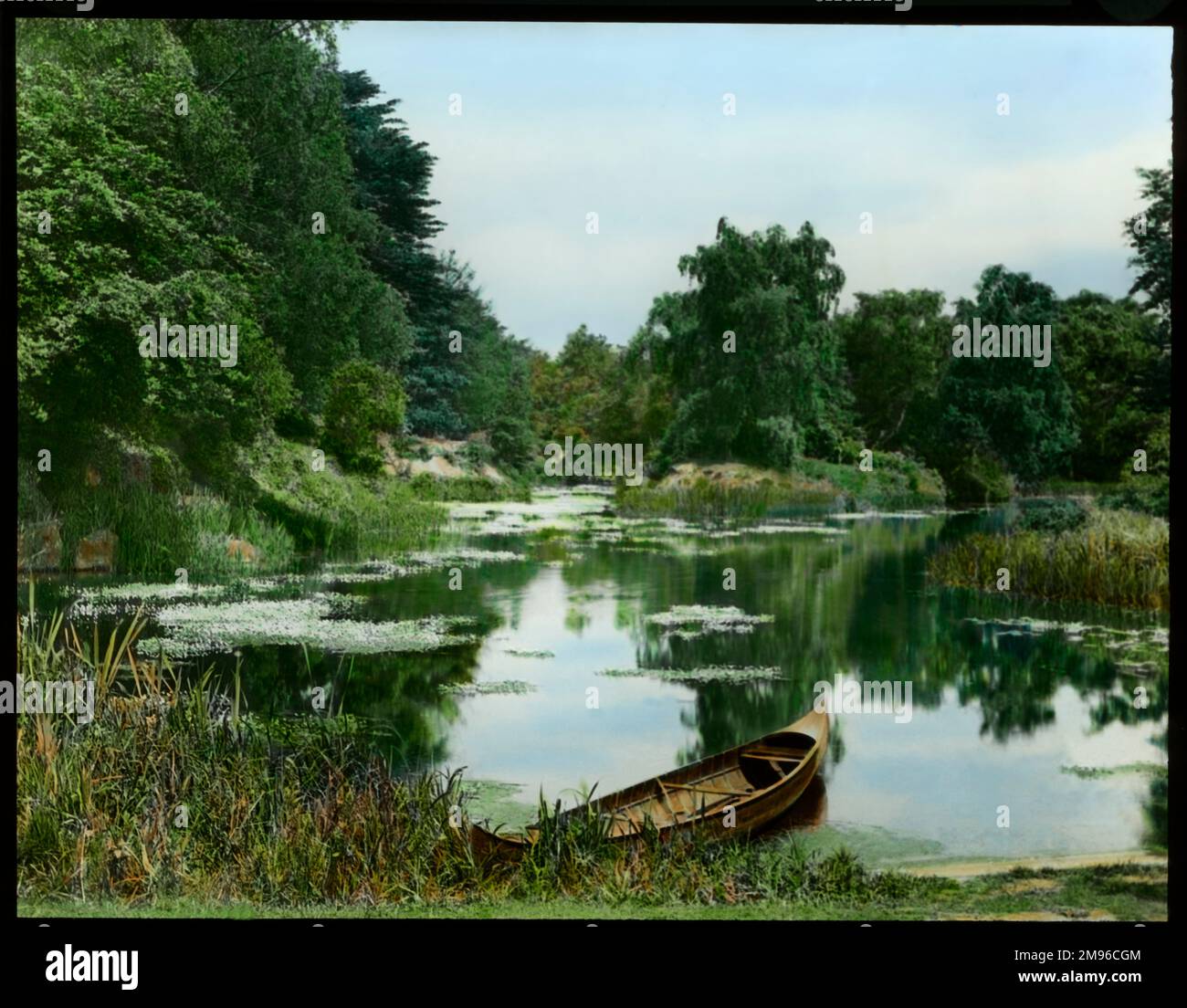 Ein Blick auf einen See im Frühsommer, mit einem Boot am Ufer. Stockfoto