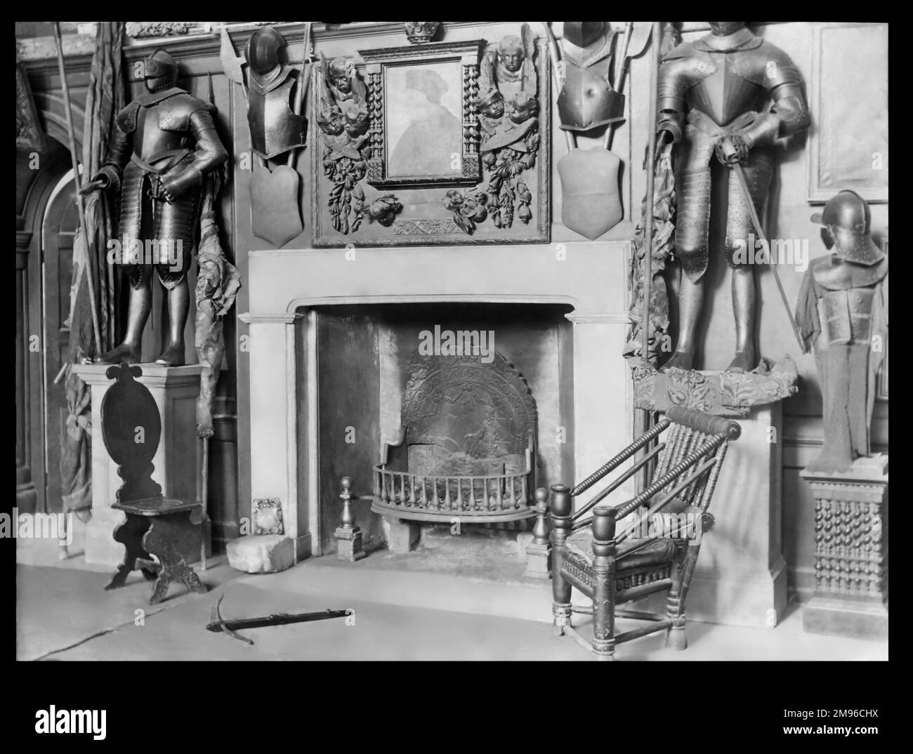Eine Innenaufnahme der Halle im Cheshunt Great House in Cheshunt, Hertfordshire, mit einem großen Kamin, zwei ungewöhnlichen Holzstühlen und verschiedenen Rüstungen. Das Gebäude stammt aus dem 15. Jahrhundert. Im 19. Und frühen 20. Jahrhundert diente sie als Freimaurer-Halle. Es wurde 1970 nach einem Brand abgerissen. Stockfoto