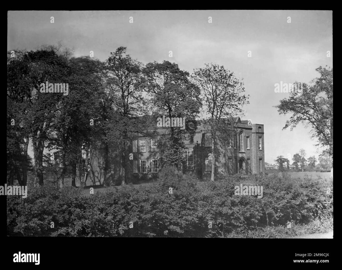 Blick durch die Bäume des Cheshunt Great House in Cheshunt, Hertfordshire. Das Gebäude stammt aus dem 15. Jahrhundert. Im 19. Und frühen 20. Jahrhundert diente sie als Freimaurer-Halle. Es wurde 1970 nach einem Brand abgerissen. Stockfoto