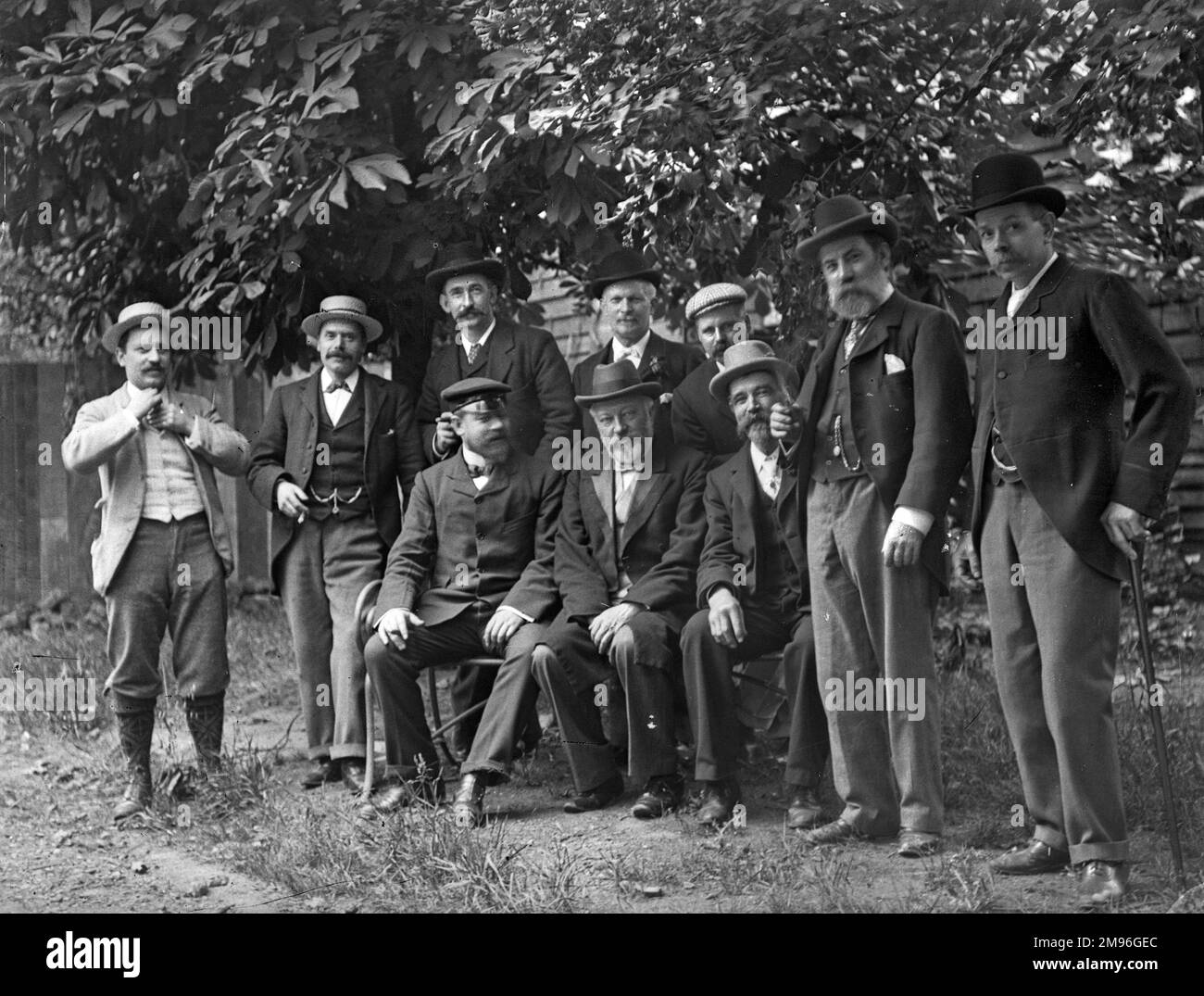 Gruppenfoto von Männern in einem Garten, einige mit Bart, andere mit Schnurrbart, die glücklich und entspannt aussehen. Stockfoto