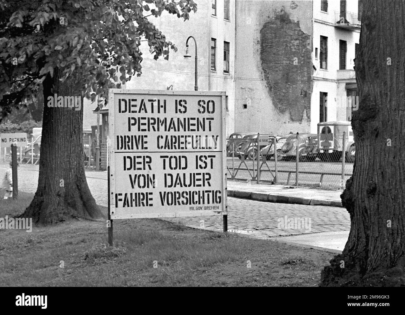 Ein Straßenschild auf Englisch und Deutsch: Der Tod ist so dauerhaft, fahr vorsichtig. Stockfoto