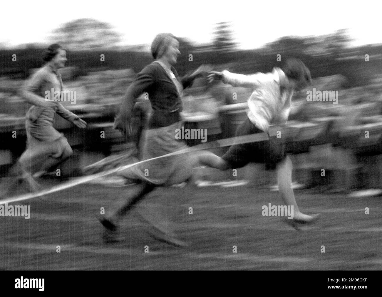 Rennfrauen erreichen mit diesem rasanten Actionshot die Ziellinie. Stockfoto