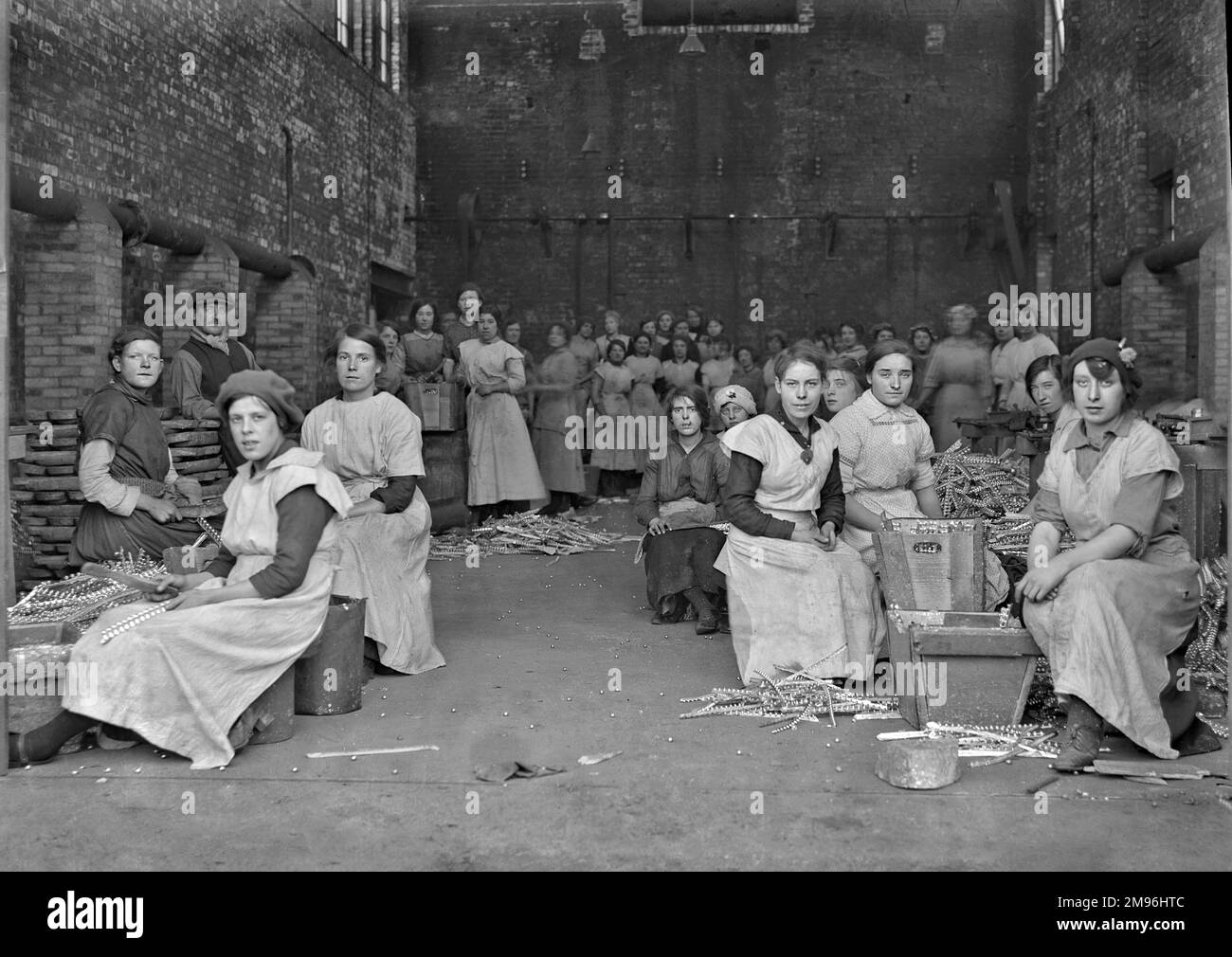 Eine Gruppe von Arbeitern, meist Frauen, in einer Fabrik, die Bleischrapnell für Kunstgegenstände herstellt - WW1. Stockfoto