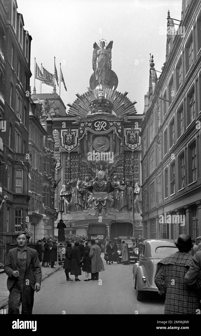 Eine schmale Londoner Straße mit einer Ausstellung, die den Beitritt von König George VI. Kennzeichnet Stockfoto