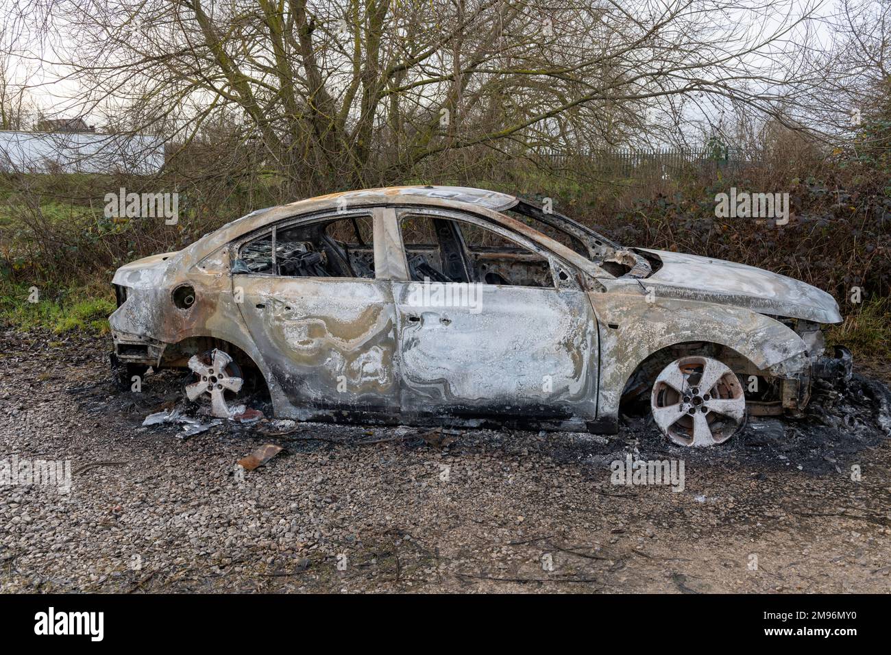 Ein ausgebranntes, modernes Auto, das in Großbritannien auf dem Müllgrund stehen gelassen wurde Stockfoto