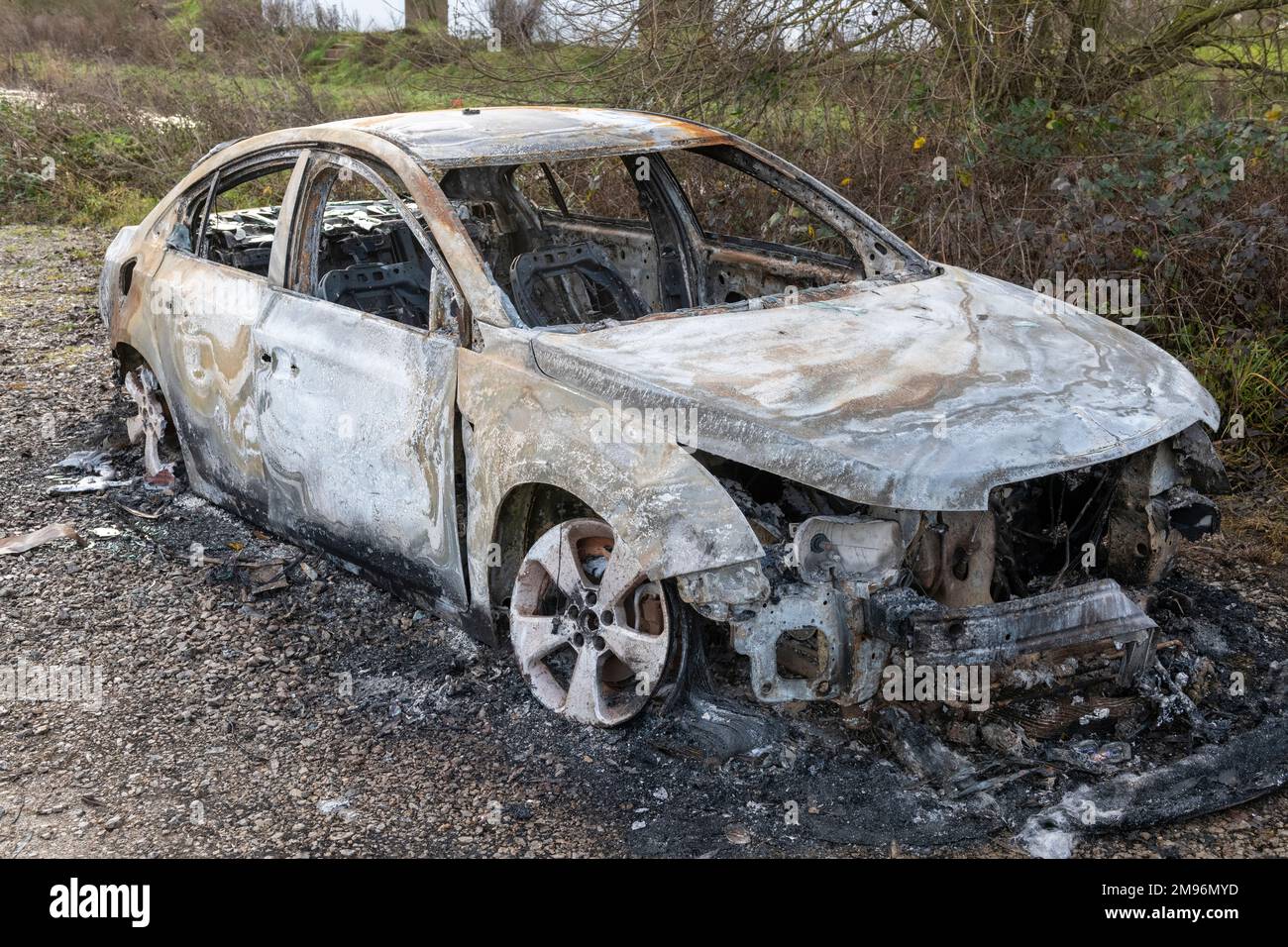 Ein ausgebranntes, modernes Auto, das in Großbritannien auf dem Müllgrund stehen gelassen wurde Stockfoto