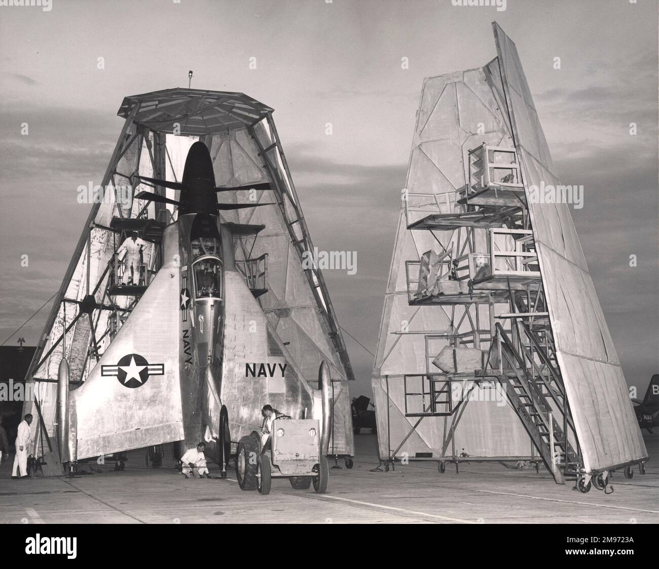 Ein Traktor manövriert den Convair XFY-1 Pogo VTOL-Jäger in Position für die Unterbringung in seinem Hangar an der Brown Field Naval Auxialiary Station in der Nähe von San Diego, Kalifornien. Stockfoto