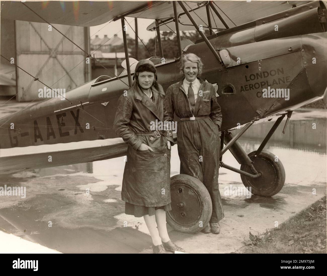 Pauline Gower (1910-1947) (links) und Dorothy Spicer neben A de Havilland DH60G Gipsy Moth, G-AAEX. Sie waren das erste Unternehmen, das ein ausschließlich weibliches Freudenreiten-Unternehmen führte, Air Tours Ltd, gegründet 1931. Stockfoto