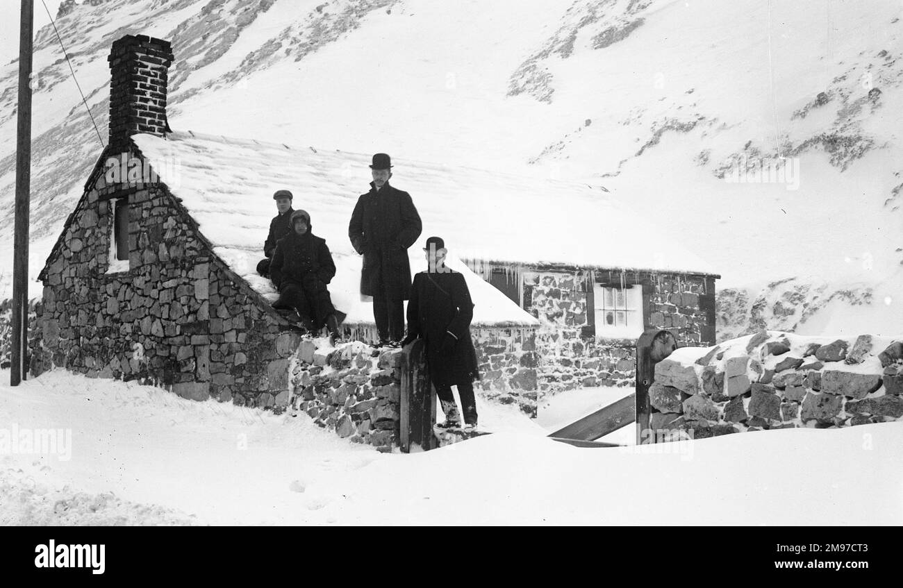 Eine Gruppe Männer im Schnee, Dove Holes, Derbyshire, vor einem Häuschen im Januar 1908 Stockfoto