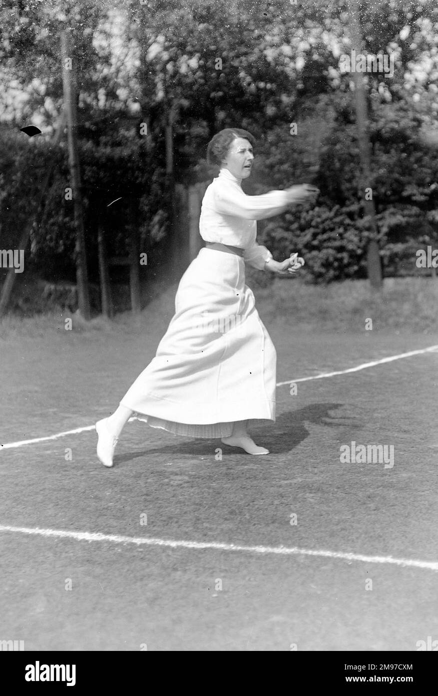 Lady Tennis-Spieler in Aktion im Moorfield Tennis Club, Stockport, zeigt, wie das Kleid der Zeit einen begeisterten Spieler eingeschränkt haben muss. Stockfoto
