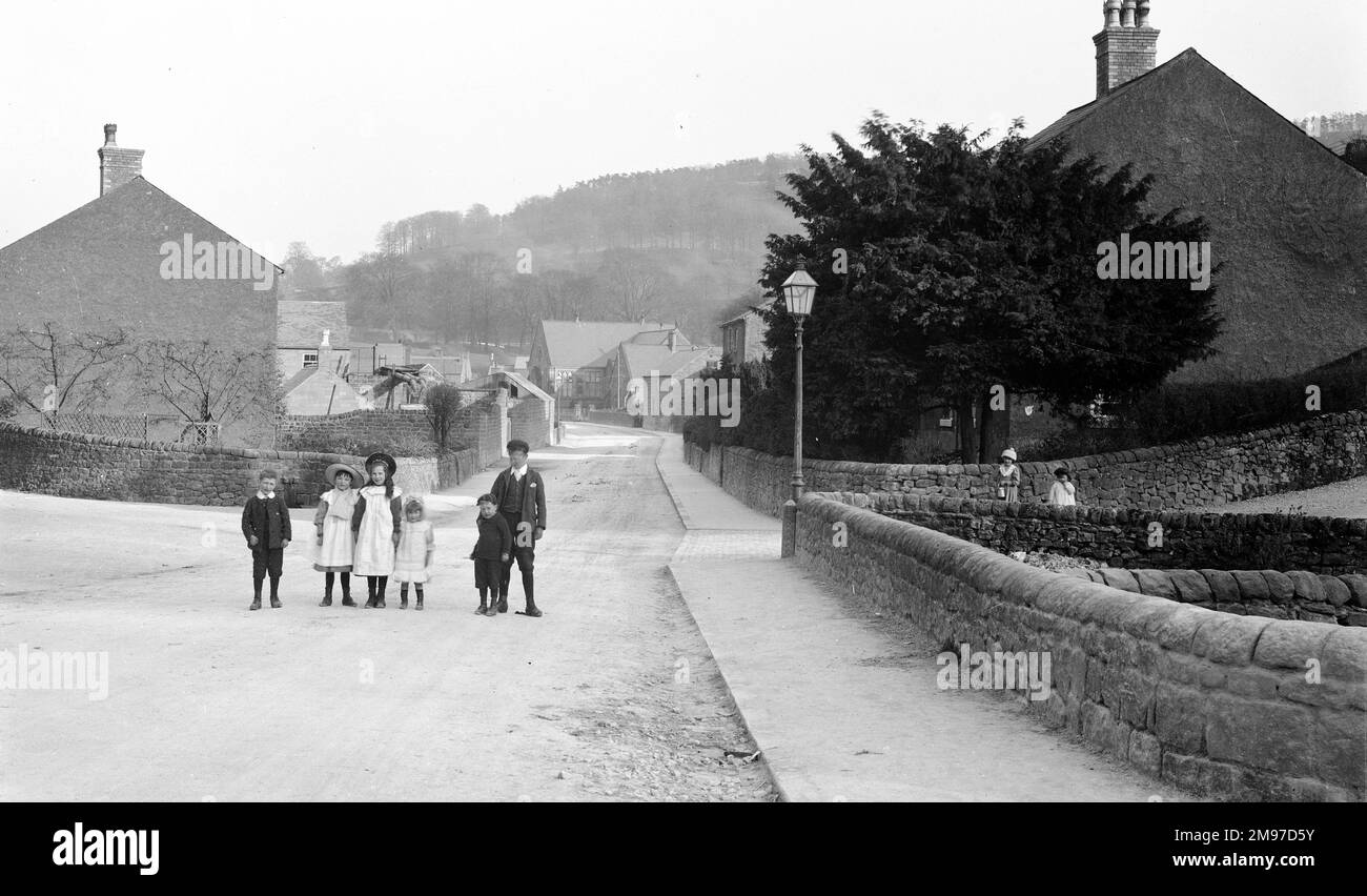 Cromford - eine Gruppe von Kindern auf der Straße, die Alltagskleidung aus dem Jahr 1906 zeigt und auch die Neuheit der damals verwendeten Kameras illustriert. Stockfoto