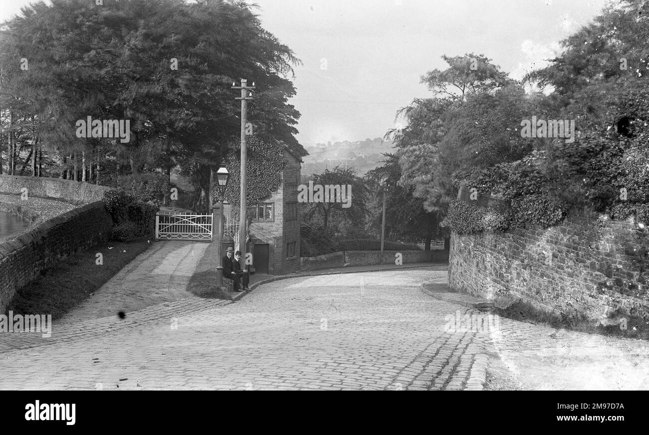 Diese Sichtweise ist zwar nicht mehr verstümmelt, aber sie ist noch so groß wie vor über 100 Jahren, als diese Fotografie gemacht wurde. George Potter, Mitarbeiter und Freund des Fotografen, ist die linke Hand der beiden sitzenden Männer. Das Haus dahinter war in den 1970er Jahren im Besitz von Professor Hyde vom Universitätsklinikum für Geschichte von Manchester. Stockfoto