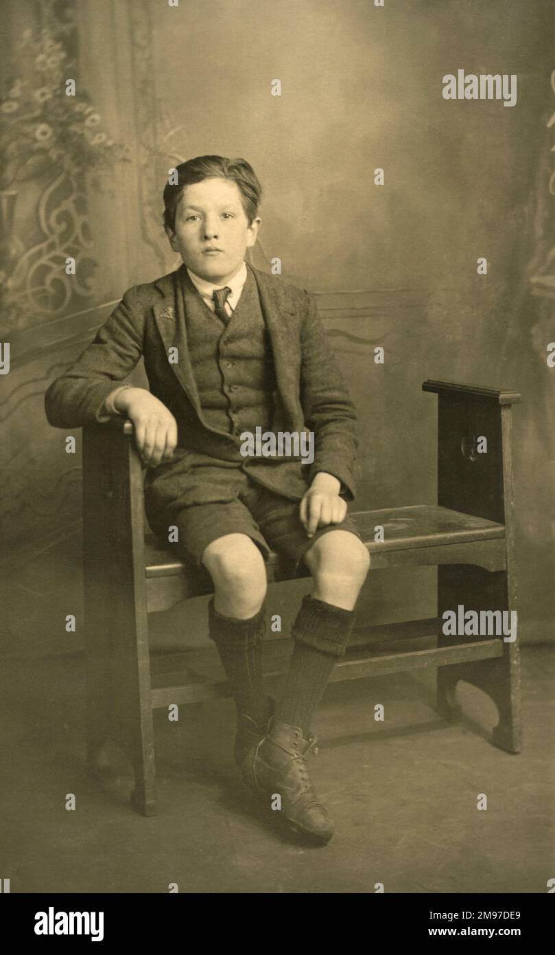 Ein Junge in Weste, Jacke, Krawatte und Shorts posiert für die Kamera. Stockfoto