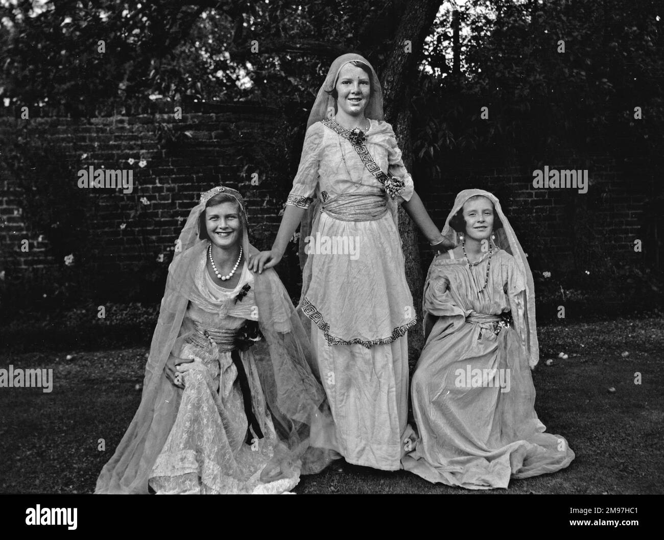 Drei Frauen, die ein schickes Kleid im Garten tragen. Stockfoto