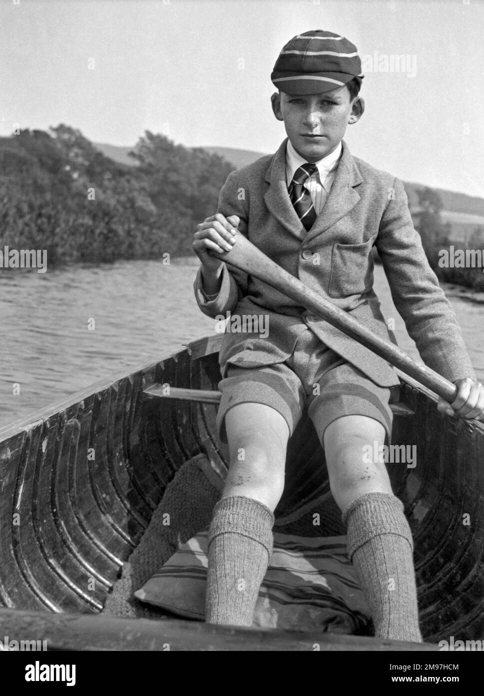 Ein Junge in Schuluniform rudert ein Boot. Stockfoto