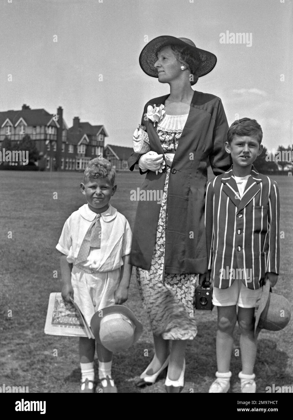 Frau und zwei Jungs in ihren besten Kleidern. Stockfoto
