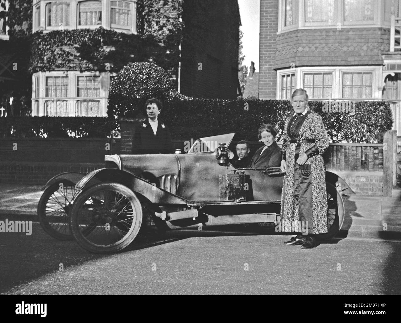 Leute mit einem offenen Auto in einer Vorstadtstraße. Stockfoto