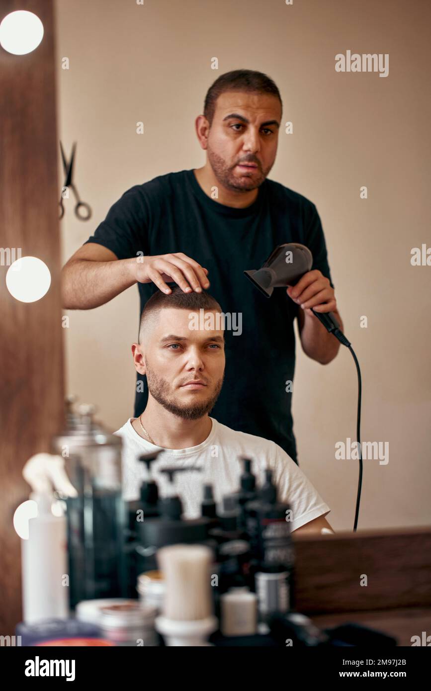 Friseur während der Arbeit mit dem Kunden im Friseursalon Stockfoto