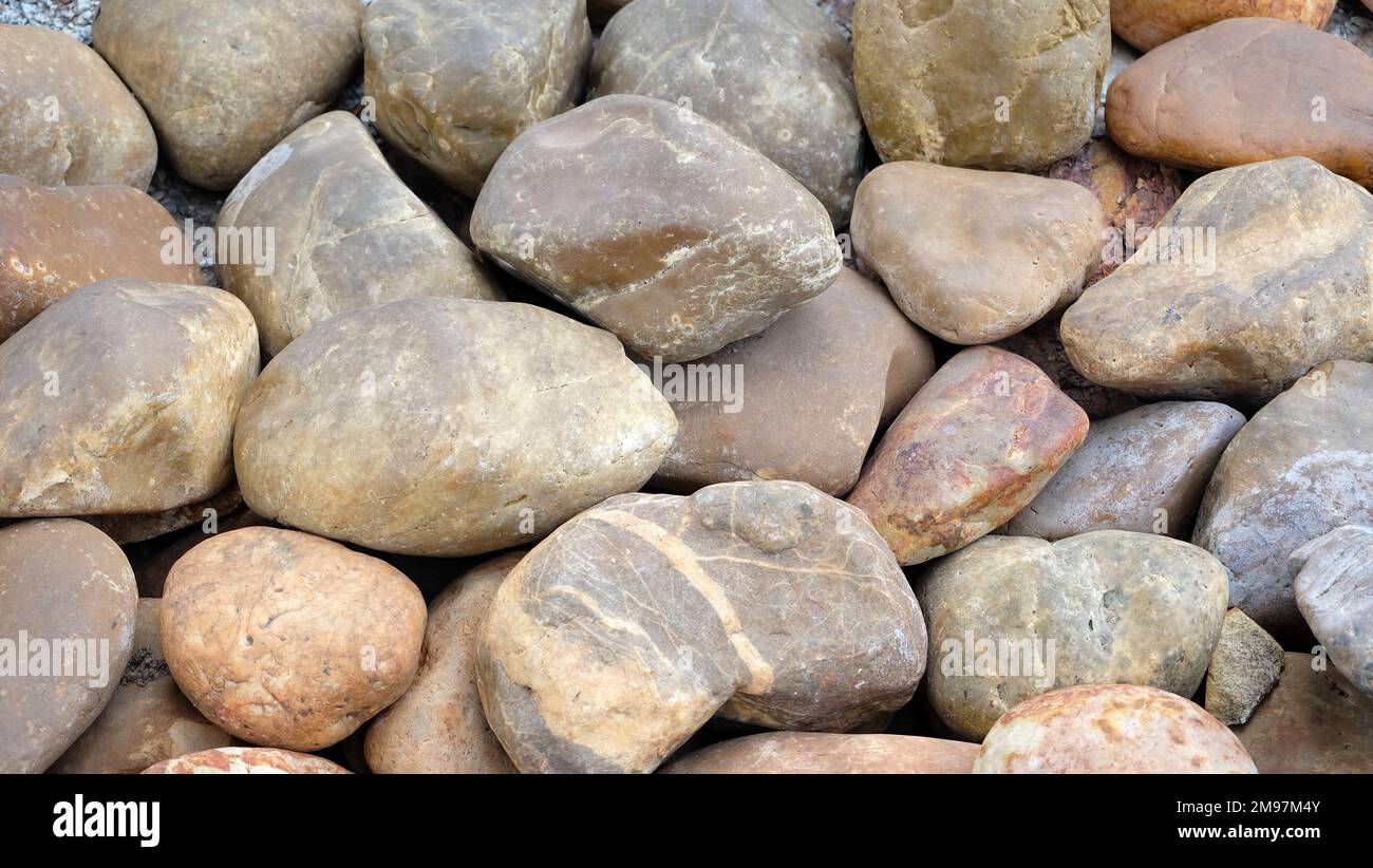 Hintergrundmuster von Flussfelsen mit abgerundeten Ecken und einer glatten Oberfläche. Stockfoto