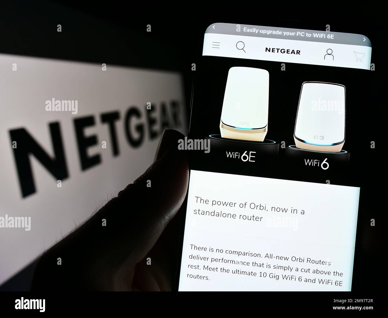 Person, die ein Smartphone mit einer Website des US-amerikanischen Computernetzwerkunternehmens Netgear Inc. Auf dem Bildschirm vor dem Logo hält. Konzentrieren Sie sich auf die Mitte des Telefondisplays. Stockfoto