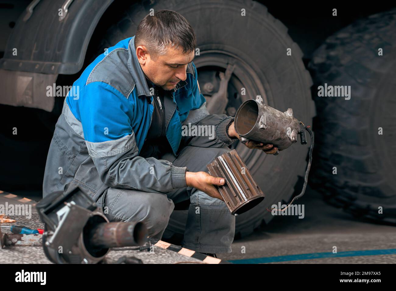 Automechaniker repariert Lkw. Professionelle Reparatur und Diagnose von Frachttraktoren und -Ausrüstung. Der Mechaniker in der Werkstatt berücksichtigt Ersatzteile. Stockfoto