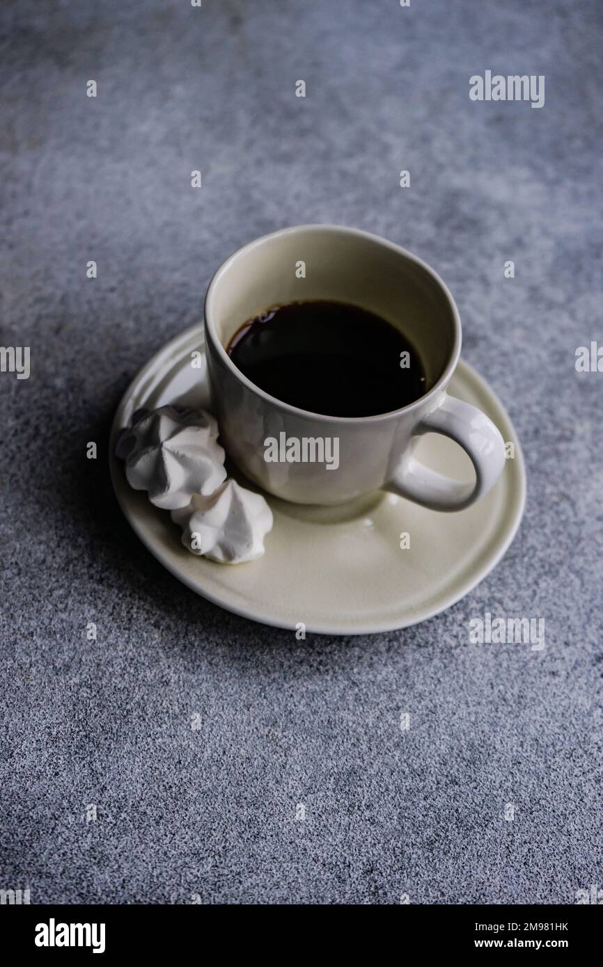 Nahaufnahme einer Tasse schwarzen Kaffees mit kleinen Baiser-Küssen Stockfoto