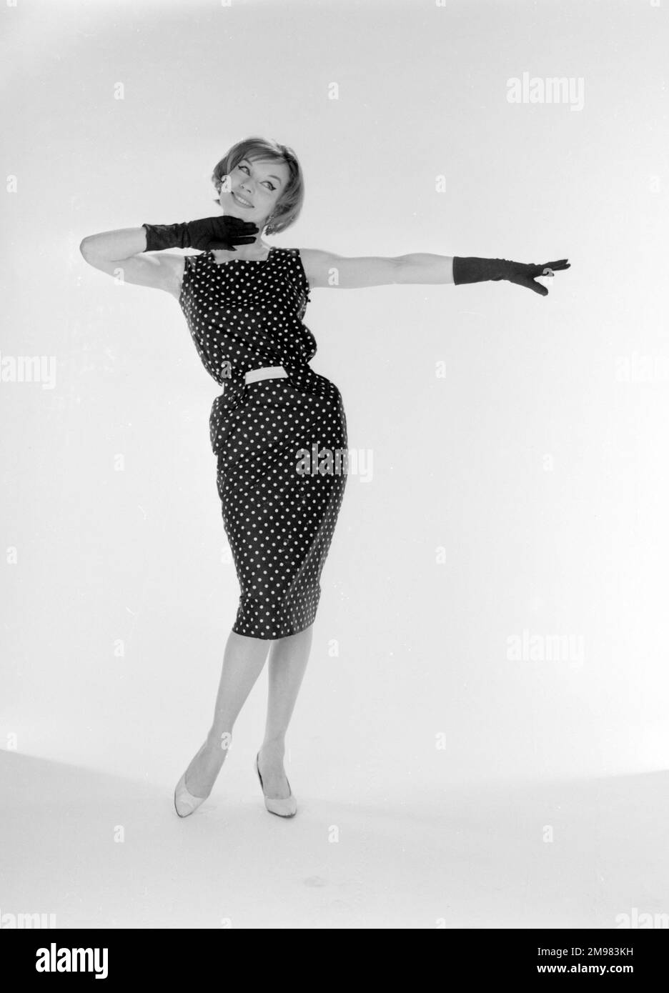 Werbung für die Mond Nickel Company -- weibliches Model (Jane Davis) in gepunktetem Kleid und Handschuhen. Stockfoto