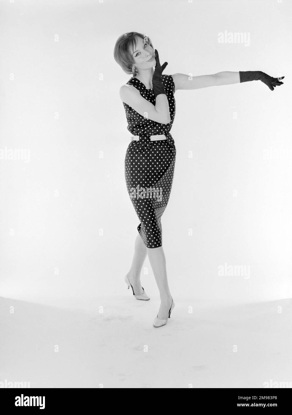 Werbung für die Mond Nickel Company -- weibliches Model (Jane Davis) in gepunktetem Kleid und Handschuhen. Stockfoto