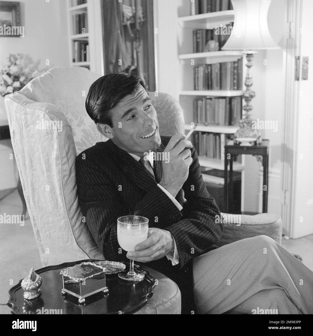 Advertisement for Life Cigarettes -- männliches Model (Peter Anthony), das sich in einer luxuriösen Inneneinrichtung posiert. Stockfoto