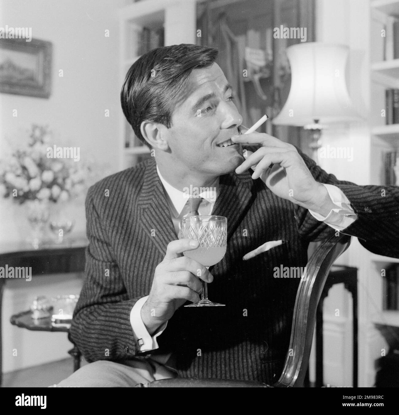Advertisement for Life Cigarettes -- männliches Model (Peter Anthony), das sich in einer luxuriösen Inneneinrichtung posiert. Stockfoto