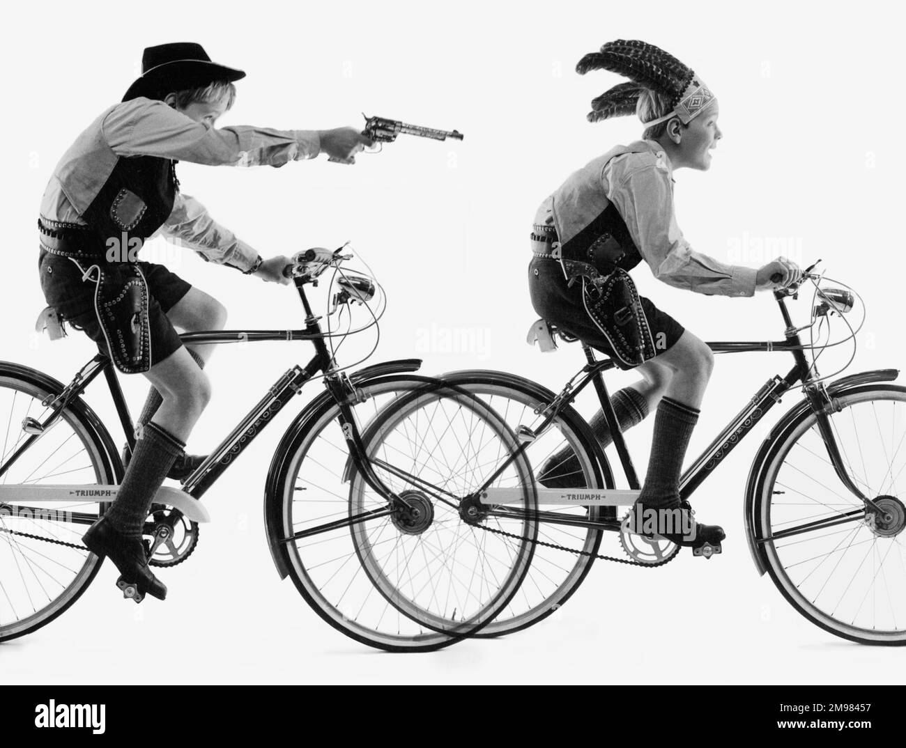 Werbung für Triumph-Fahrräder -- zwei junge Models, die Cowboys und Indianer spielen. Stockfoto