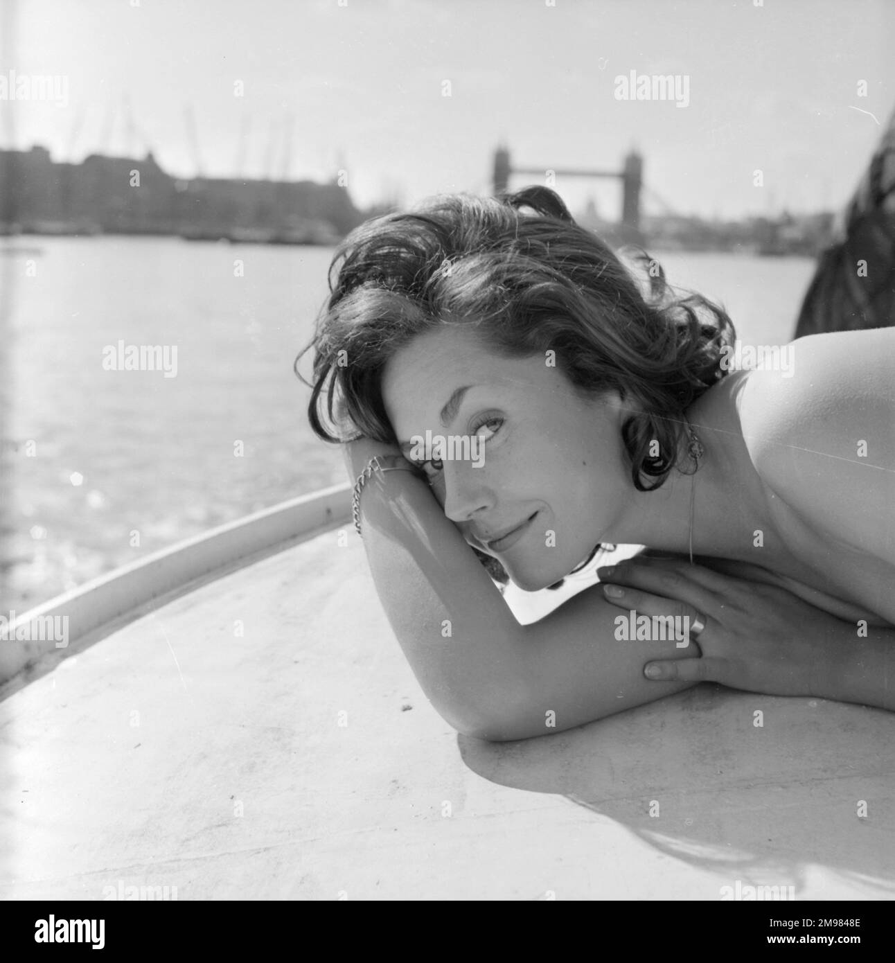 Junge Frau (Model - Geraldine Hill), die auf einem Boot auf der Themse modelliert. Stockfoto