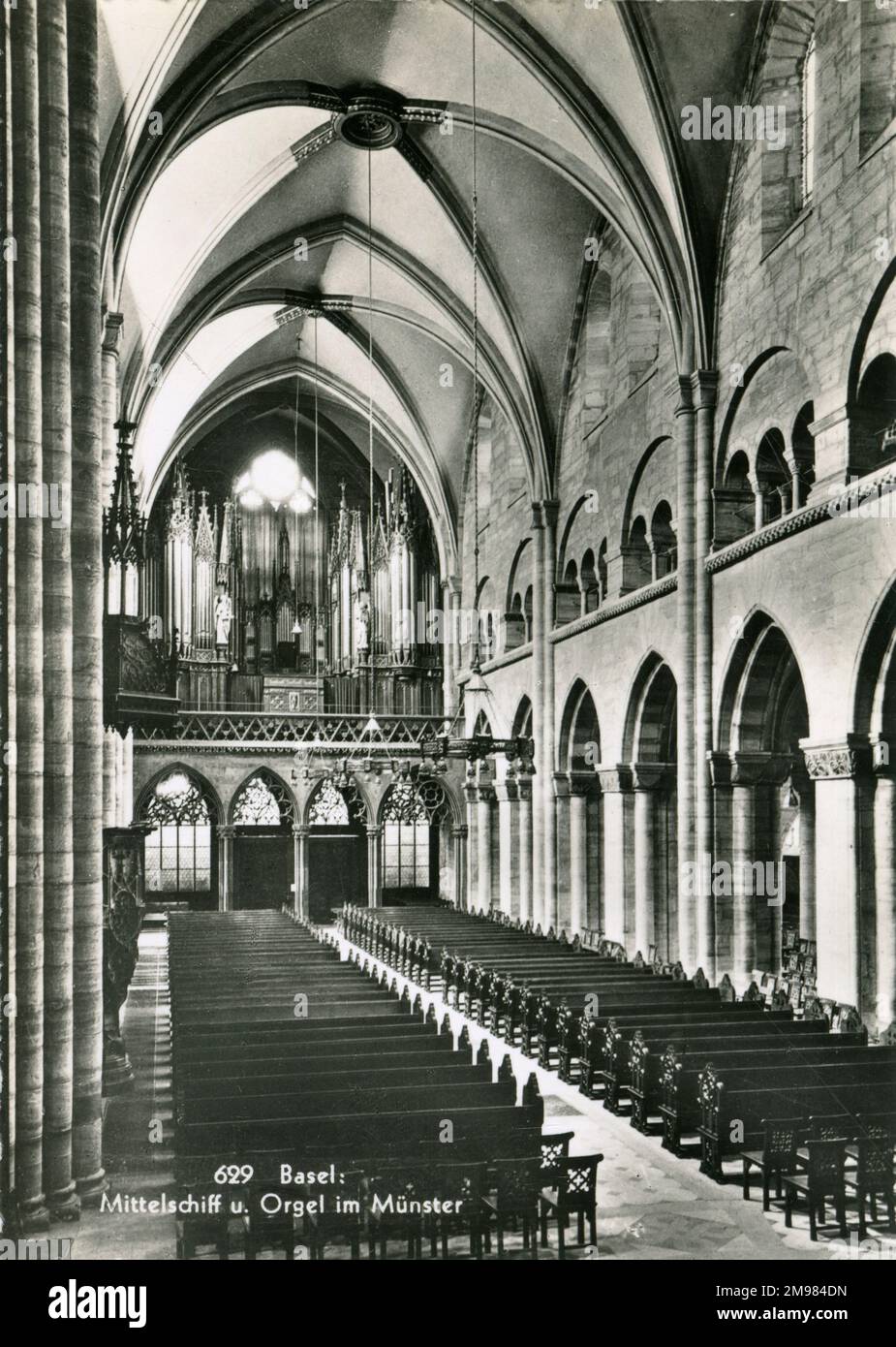 Basel, Schweiz - das Innere der Basler Münsterkirche, erkennbar aus rotem Sandstein mit farbigen Dachziegeln im gotischen und romanischen Stil erbaut. Das Nabel ist abgebildet, zusammen mit den Orgelpfeifen am anderen Ende Stockfoto