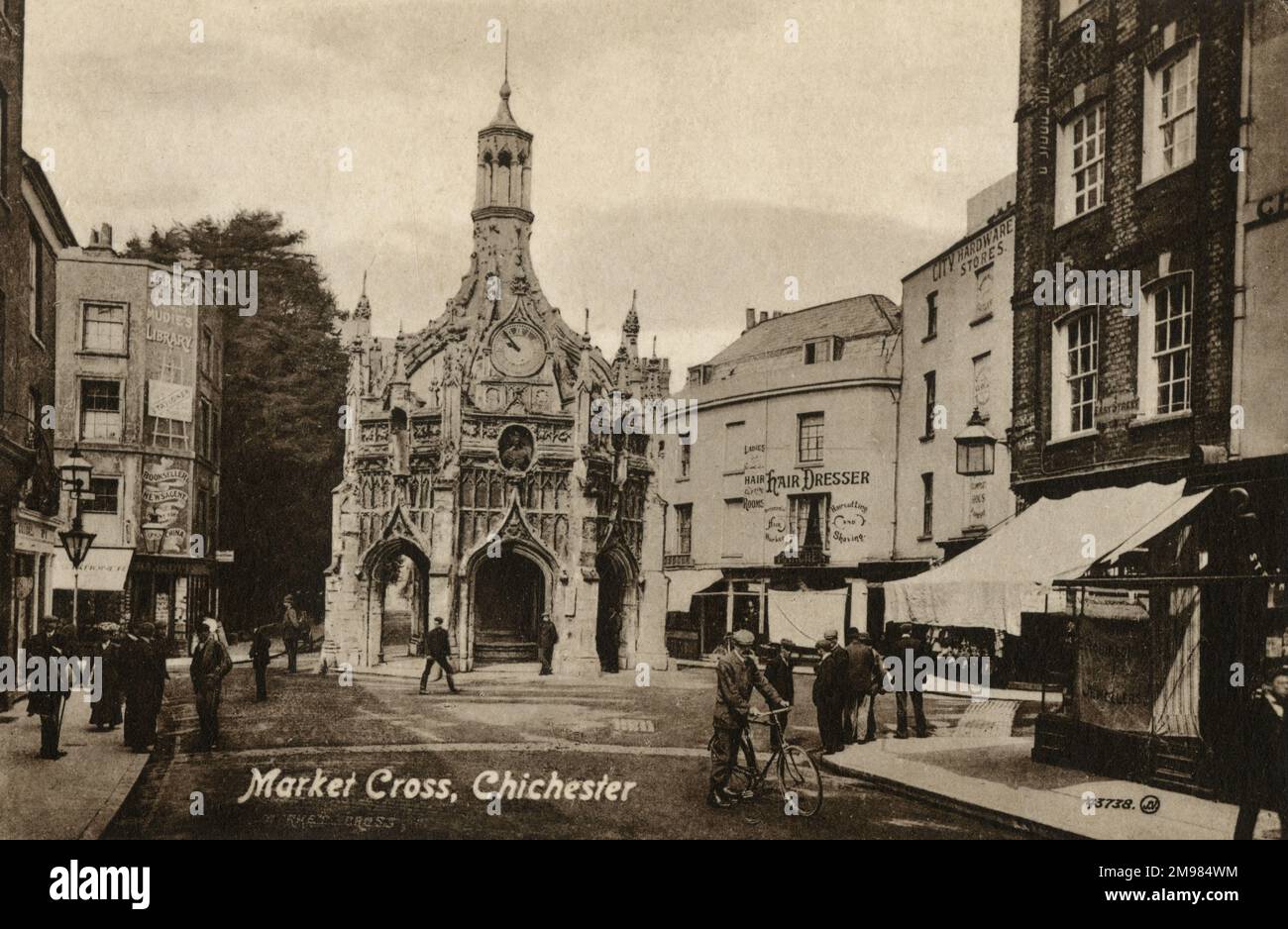 Chichester Cross ist ein aufwändiges, rechtwinkliges Marktkreuz in der Mitte des Marktplatzes, erbaut von Edward Story, Bischof von Chichester. Das Market Cross ist aus Caen-Stein gebaut, die Mittelsäule scheint durch das Dach zu gehen und wird ohne acht fliegende Stützpfeiler gestützt. Umgeben von Geschäften und Geschäftsräumen Stockfoto