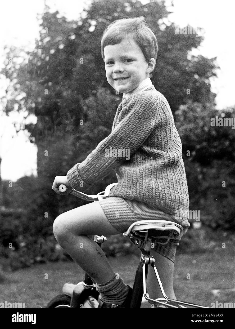 Junger Junge auf seinem Fahrrad, lächelnd. Stockfoto
