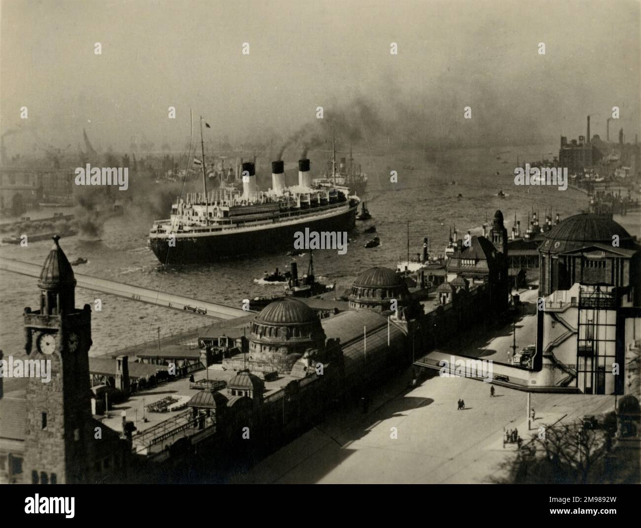 Hamburg, Deutschland - Außenansicht des Elbtunnels, der die Bezirke St. Pauli und Steinwerder mit einem großen Schiff auf dem Wasser im Hintergrund verbindet. Stockfoto